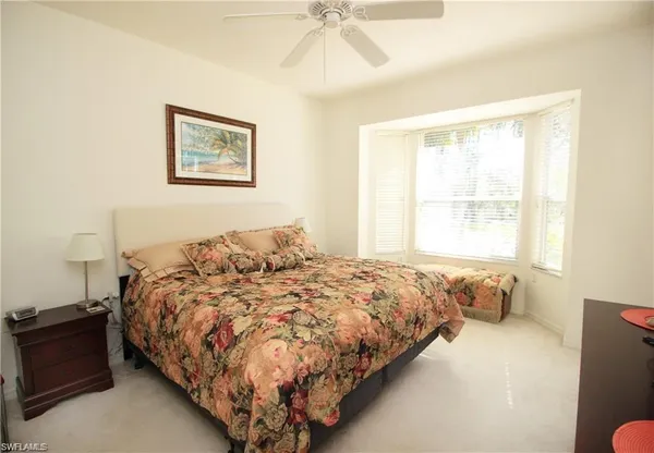 a bedroom with a bed and painting on the wall