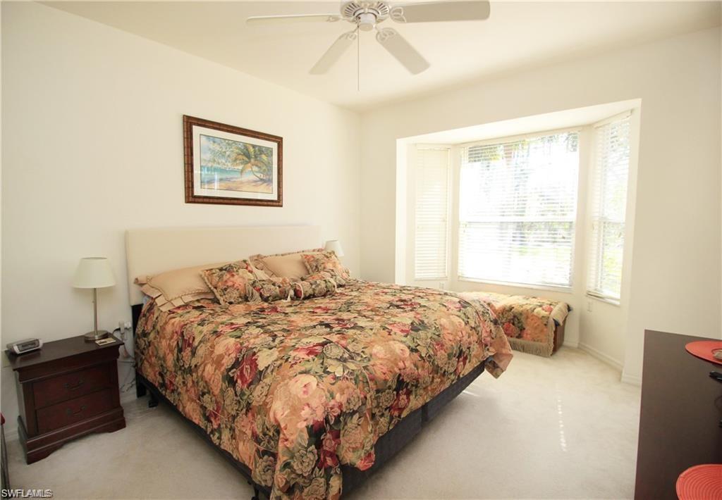 1736 Morning Sun Lane, Unit D6 Naples, FL 34119 - Photo 10 of 29 a bedroom with a bed and painting on the wall