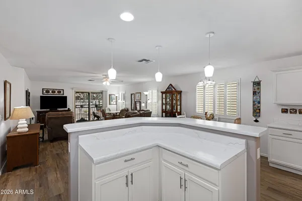 a large white kitchen with a large island oven a sink and a large window