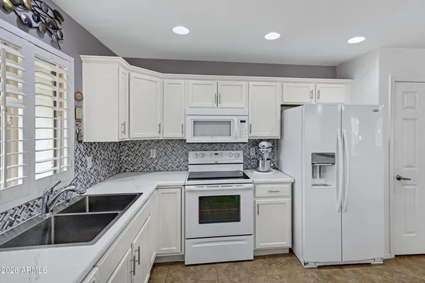 a kitchen with white cabinets and white appliances