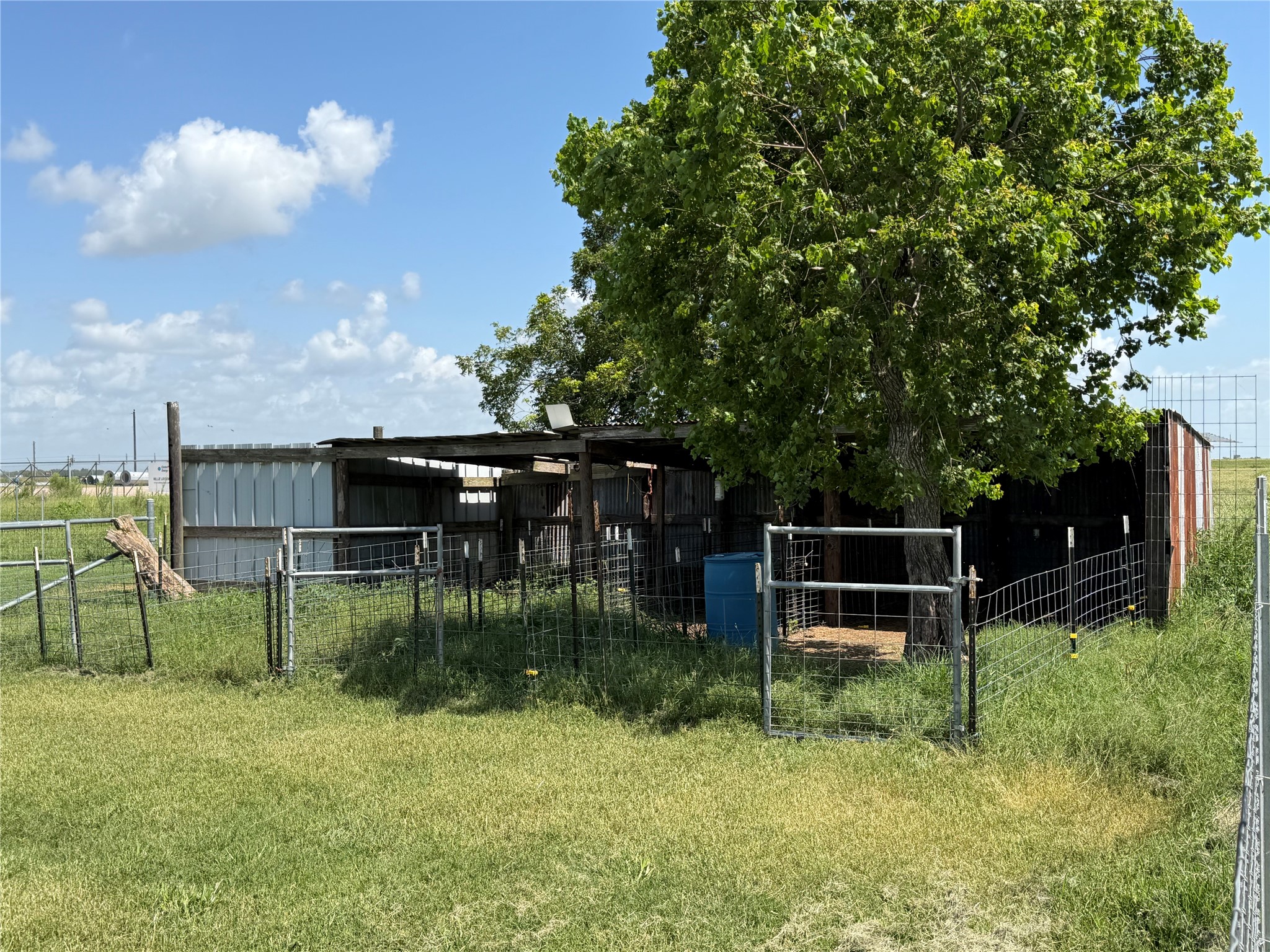 11301 South FM 441 Road El Campo, TX 77437 - Photo 40 of 43 A rustic outdoor structure with a metal roof, surrounded by fencing.