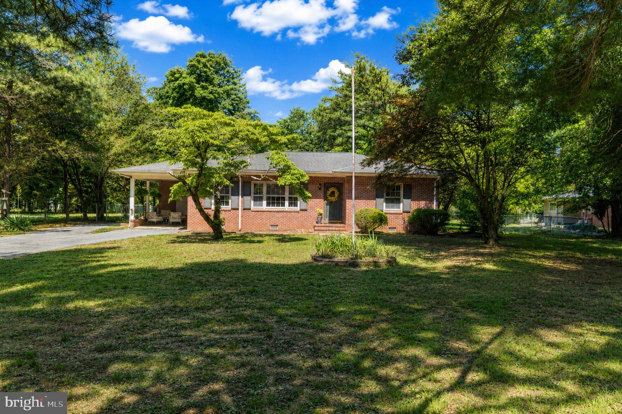 Charming brick home in lush greenery.