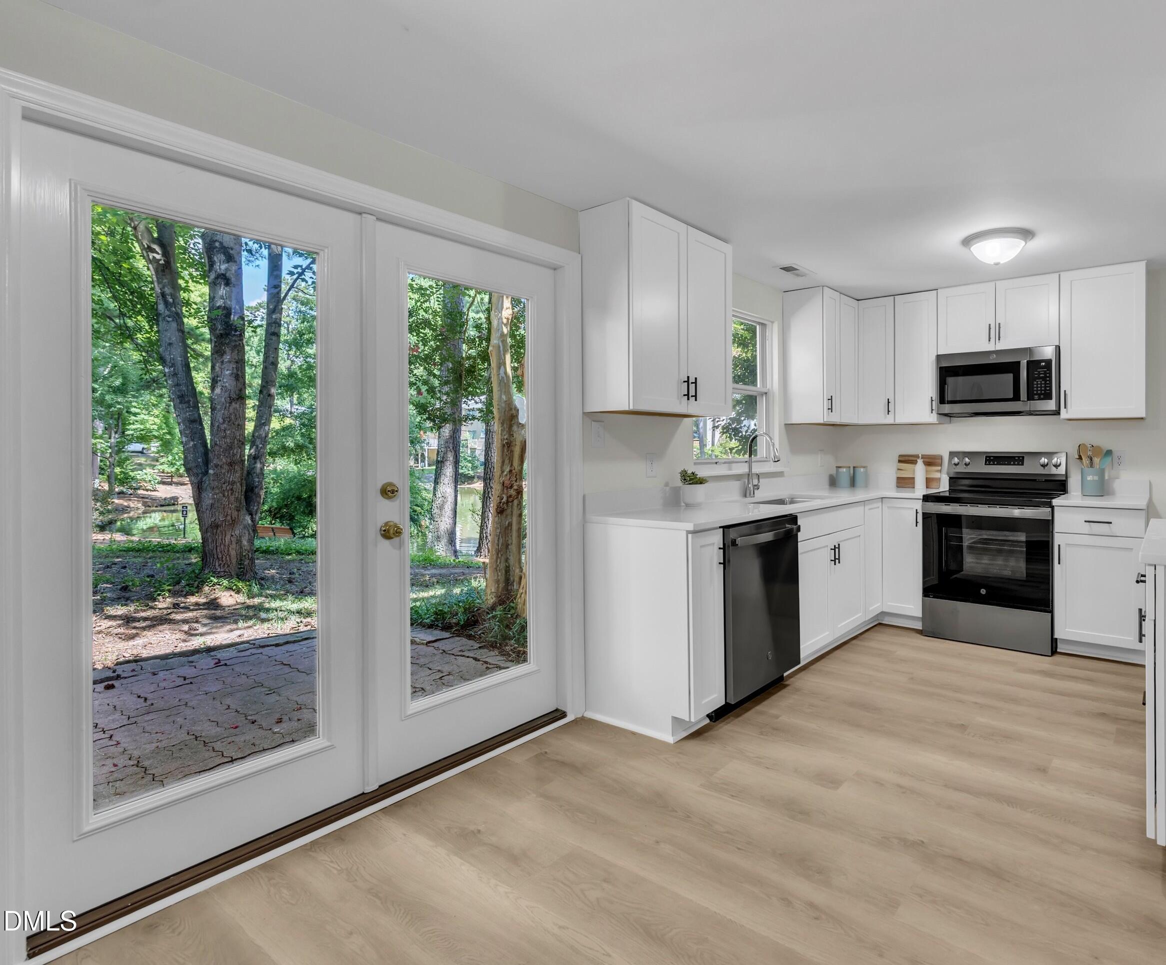 632 Middleton Avenue Cary, NC 27513 - Photo 19 of 34 a kitchen with stainless steel appliances a stove top oven sink and a window
