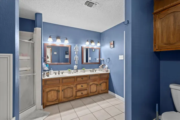 a bedroom with a large bed and a flat tv screen on dresser