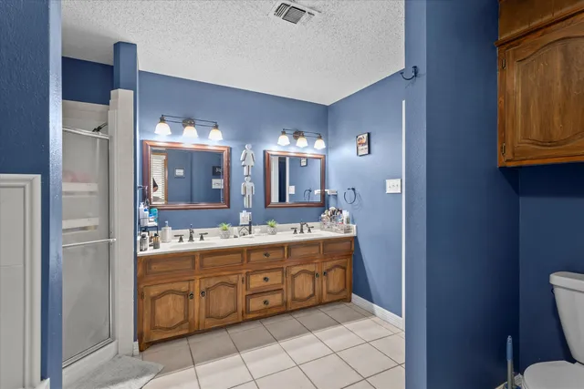 a bedroom with a large bed and a flat tv screen on dresser