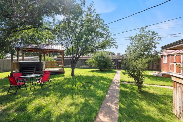 a view of a house with backyard and a tree