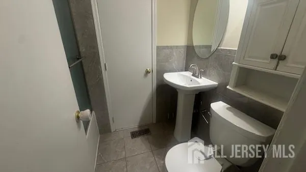 a bathroom with a sink a toilet and mirror