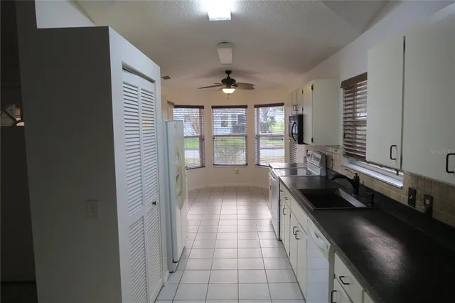 a kitchen with granite countertop a sink and a stove top oven