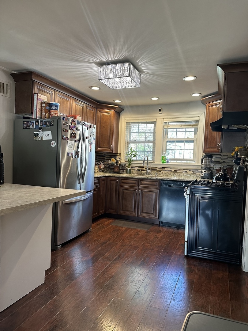 18510 Dixie Highway Homewood, IL 60430 - Photo 5 of 11 a kitchen with stainless steel appliances kitchen island granite countertop a stove a sink a refrigerator and blue cabinets with wooden floor