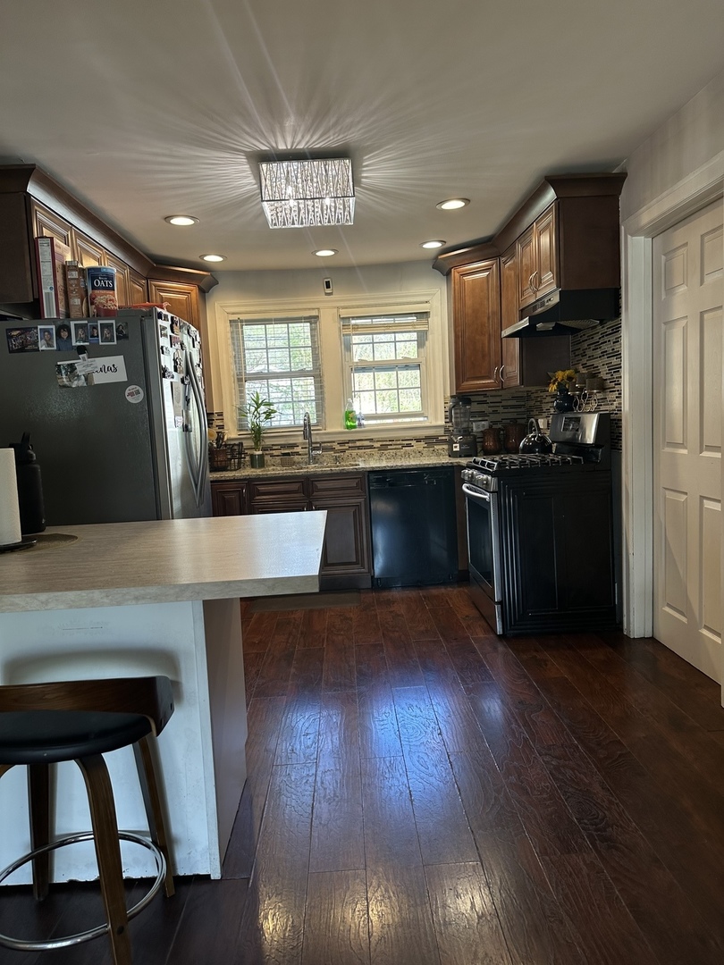 18510 Dixie Highway Homewood, IL 60430 - Photo 6 of 11 a kitchen with wooden floors and black appliances