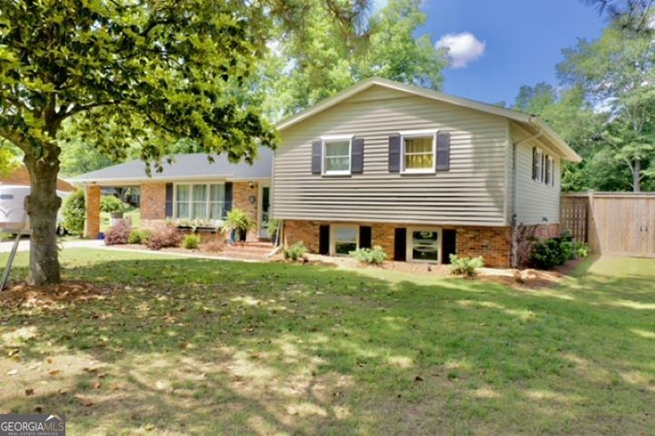 a front view of a house with a yard and trees