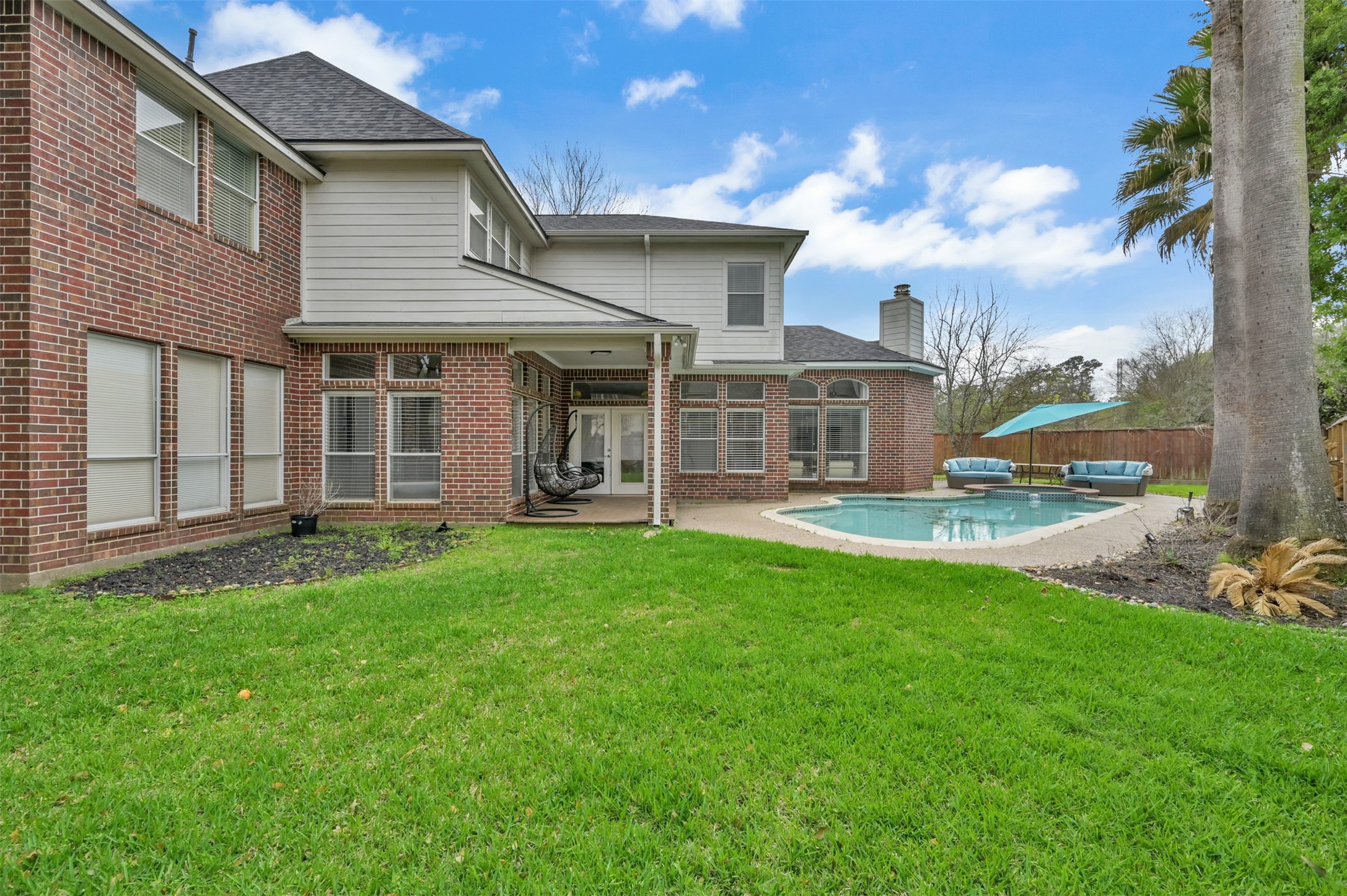 9706 Chipstead Court Spring, TX 77379 - Photo 41 of 44 Not only do you get a beautiful pool, covered patio, comfy chairs to hang out in, and a spa, you ALSO get some yard space too. SCORE!