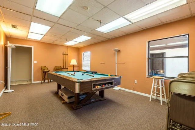 a room with pool table and windows