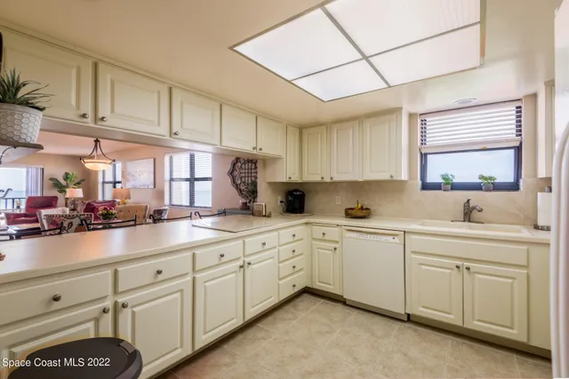 a kitchen with white cabinets and sink