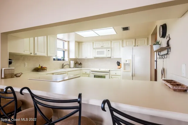 a kitchen with a table chairs stove top oven and cabinets