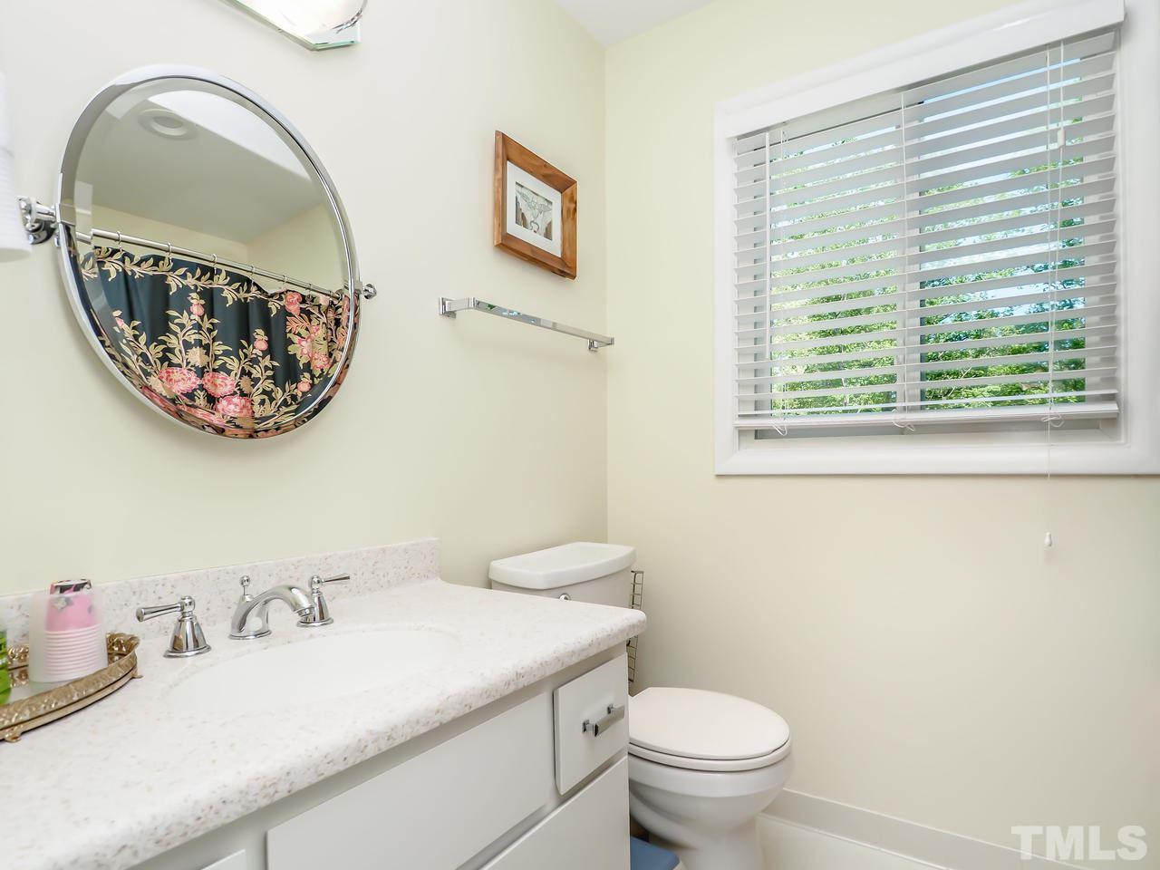 2012 Fawndale Drive Raleigh, NC 27612 - Photo 17 of 27 a bathroom with a toilet a sink and a mirror