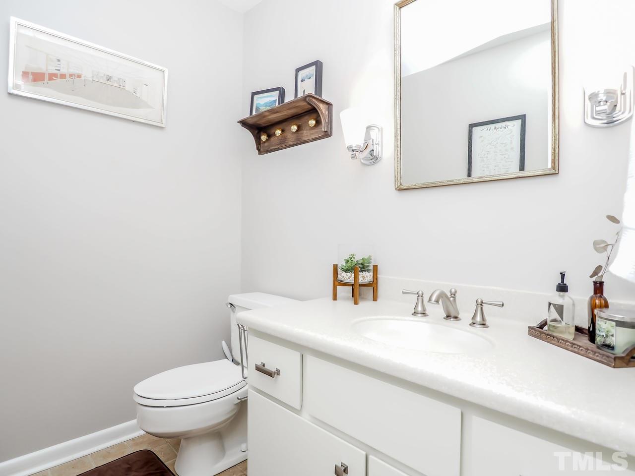 2012 Fawndale Drive Raleigh, NC 27612 - Photo 3 of 27 a bathroom with a sink a toilet and mirror