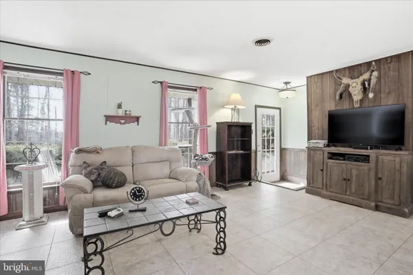 a living room with furniture a rug and a wall painting
