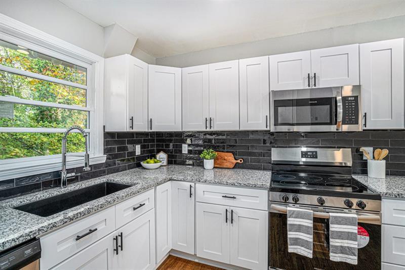 2693 Washington Street Northwest Atlanta, GA 30318 - Photo 12 of 26 a kitchen with stainless steel appliances granite countertop a stove a sink and white cabinets