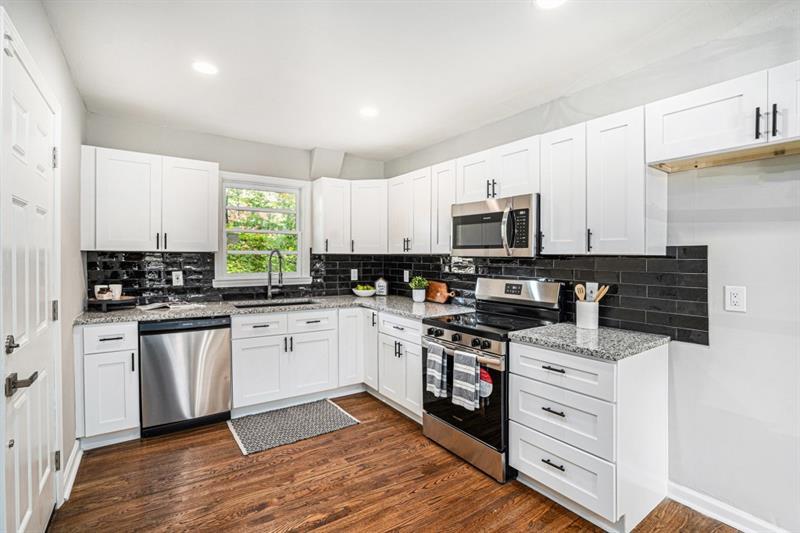 2693 Washington Street Northwest Atlanta, GA 30318 - Photo 3 of 26 a kitchen with granite countertop white cabinets and stainless steel appliances
