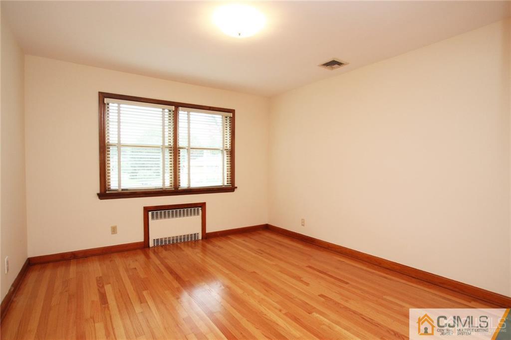 25 Academy Road Somerset, NJ 08873 - Photo 19 of 25 an empty room with wooden floor and windows
