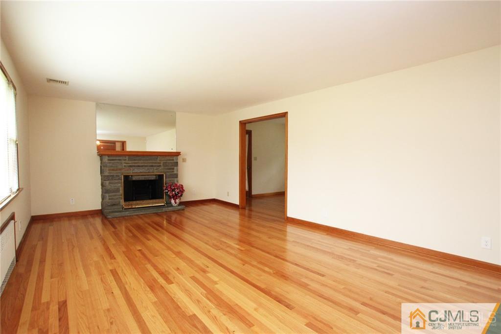 25 Academy Road Somerset, NJ 08873 - Photo 6 of 25 a view of empty room with wooden floor and fireplace
