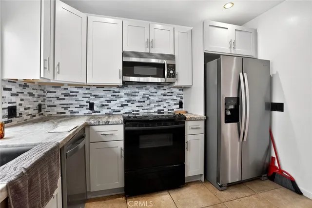 a kitchen with stainless steel appliances granite countertop a refrigerator stove and sink