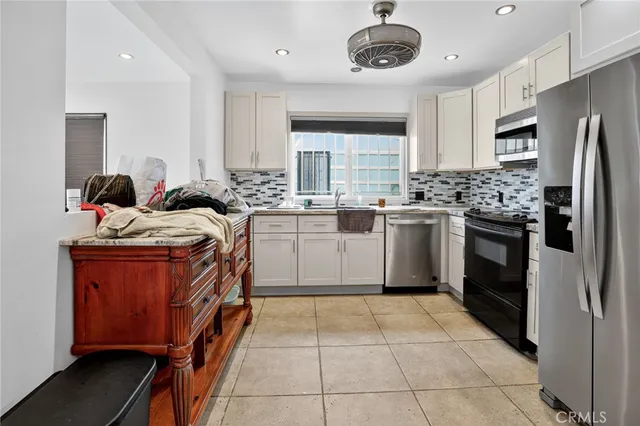 a kitchen with stainless steel appliances granite countertop a stove top oven a sink dishwasher and a refrigerator