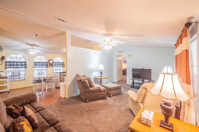 a living room with furniture and a view of kitchen
