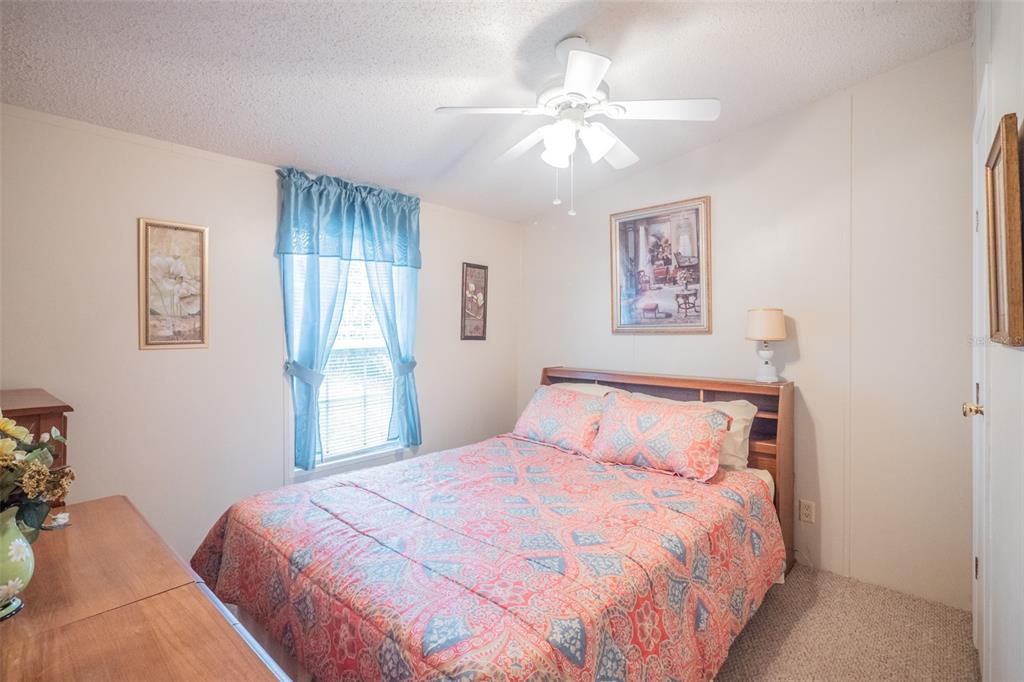 37510 Quail Ridge Circle Leesburg, FL 34788 - Photo 16 of 43 a bedroom with a large bed and a chandelier