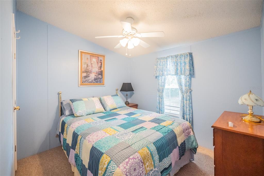 37510 Quail Ridge Circle Leesburg, FL 34788 - Photo 26 of 43 a bedroom with a bed and a chandelier