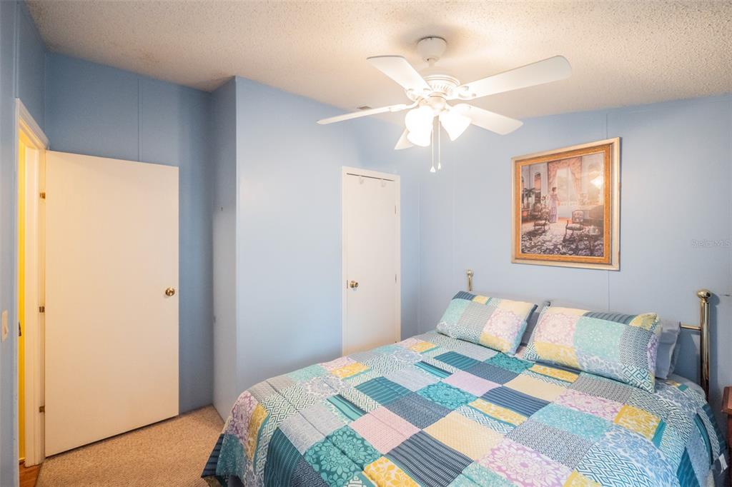 37510 Quail Ridge Circle Leesburg, FL 34788 - Photo 27 of 43 a bedroom with a bed and a chandelier