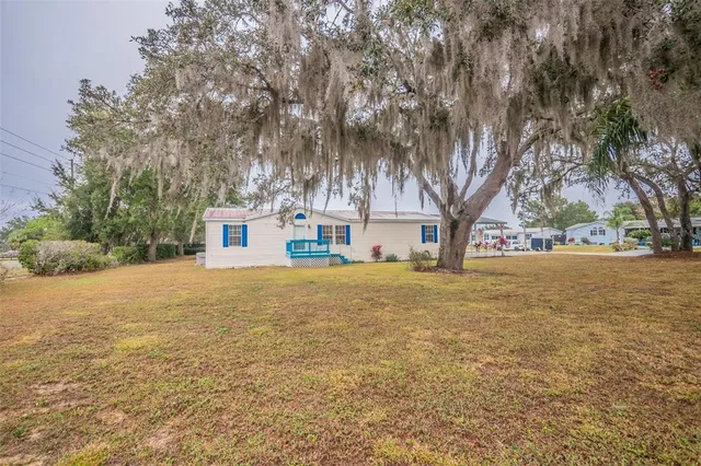 a front view of a house with a yard and trees