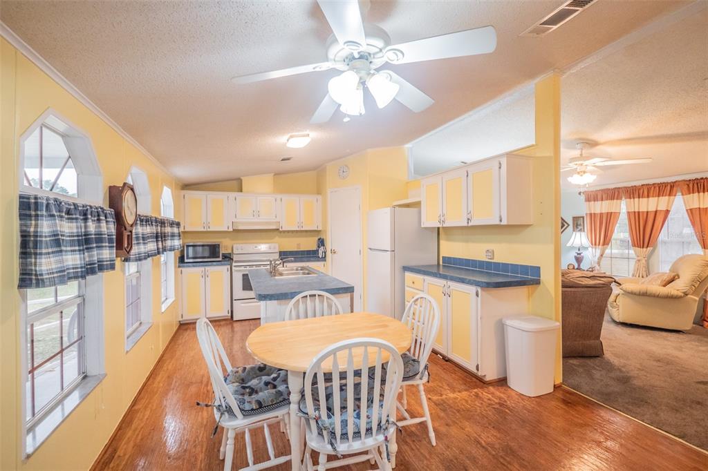 37510 Quail Ridge Circle Leesburg, FL 34788 - Photo 7 of 43 a view of a dining room with furniture a chandelier and wooden floor