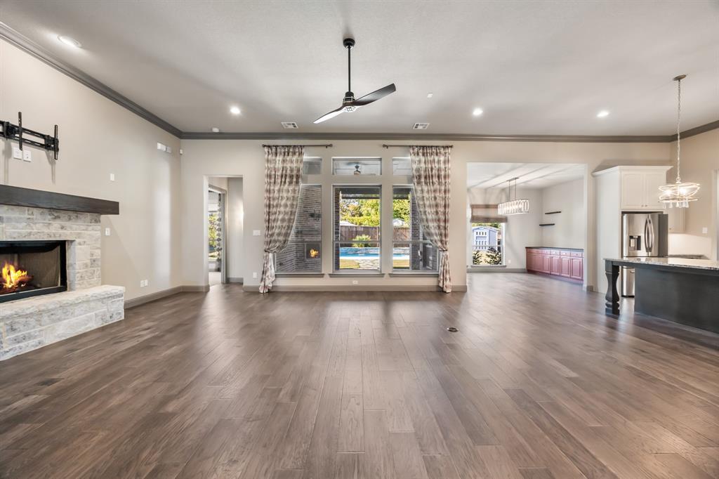 326 Prairie View Road Rockwall, TX 75087 - Photo 8 of 40 an empty room with wooden floor fireplace and windows