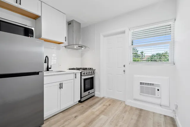 a kitchen with stainless steel appliances white cabinets and a sink