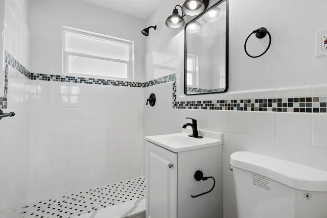 a bathroom with a sink a toilet and a mirror