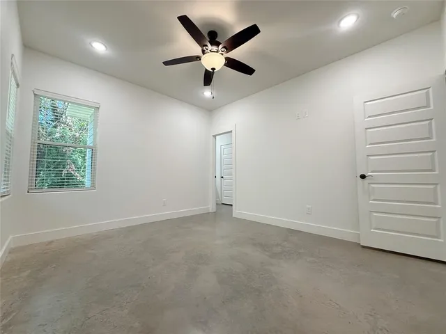 an empty room with closet and ceiling fan