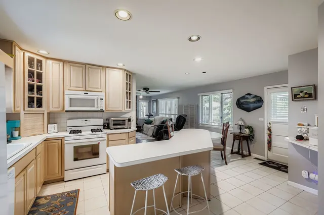 a kitchen with stainless steel appliances a sink a stove a refrigerator cabinets and a window