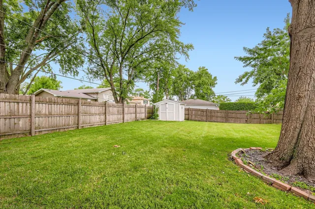 a view of a house with backyard and a garden