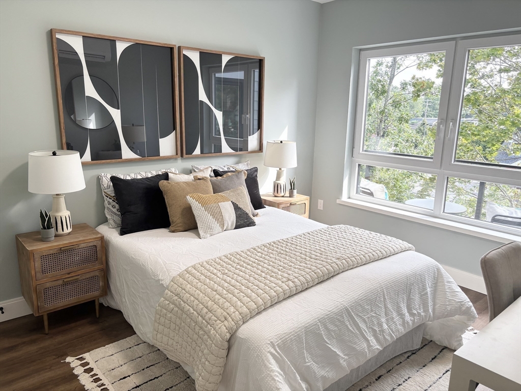 1391 Main Street, Unit 301 Walpole, MA 02081 - Photo 14 of 22 a bedroom with a bed and wooden floor