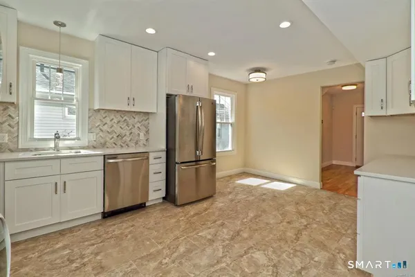 a kitchen with a refrigerator sink stove and cabinets