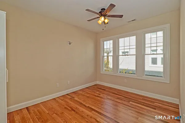 an empty room with a window and wooden floor