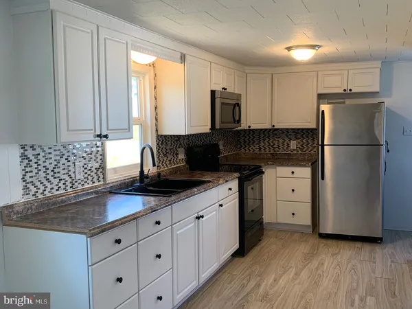 a kitchen with granite countertop a sink stainless steel appliances and cabinets