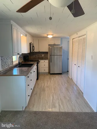 a kitchen with granite countertop a sink and refrigerator