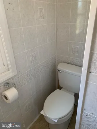a white toilet sitting next to a bathroom sink and vanity