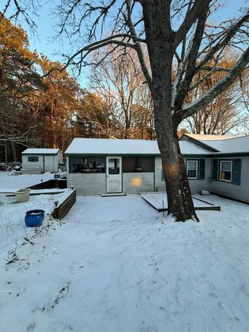 a view of a house with backyard and a tree