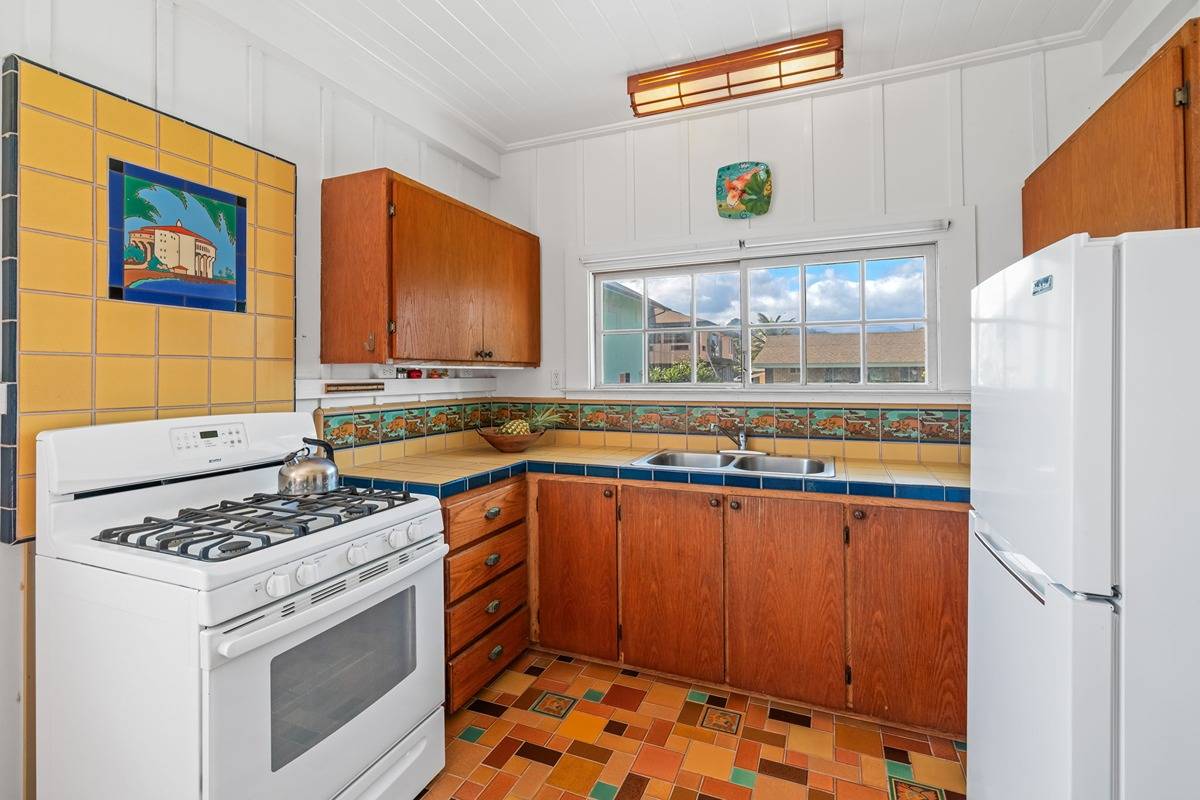1085 Moanakai Road Kapaa, HI 96746 - Photo 16 of 24 a kitchen with a stove a refrigerator and a sink
