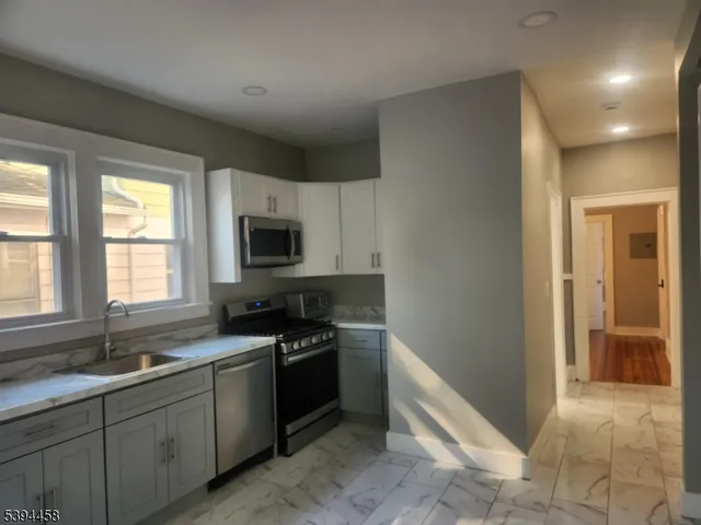 a kitchen with stainless steel appliances granite countertop a sink and a stove