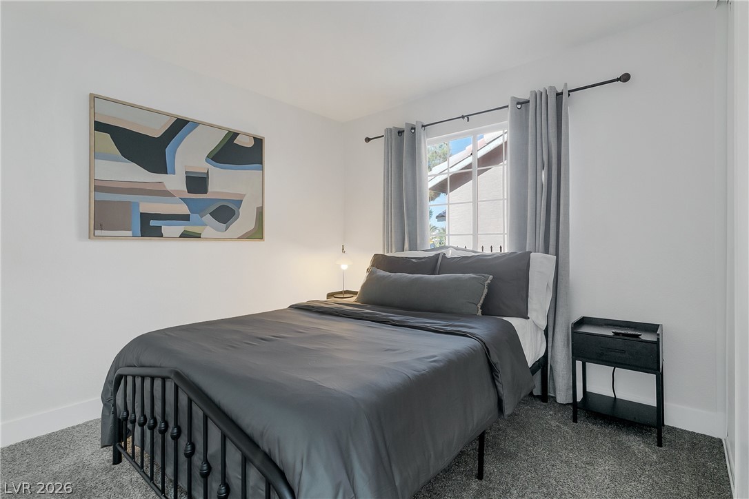 101 Beaver Ridge Avenue North Las Vegas, NV 89031 - Photo 20 of 42 A well-lit bedroom features plush carpeting and a window offering a peek at the surrounding architecture.